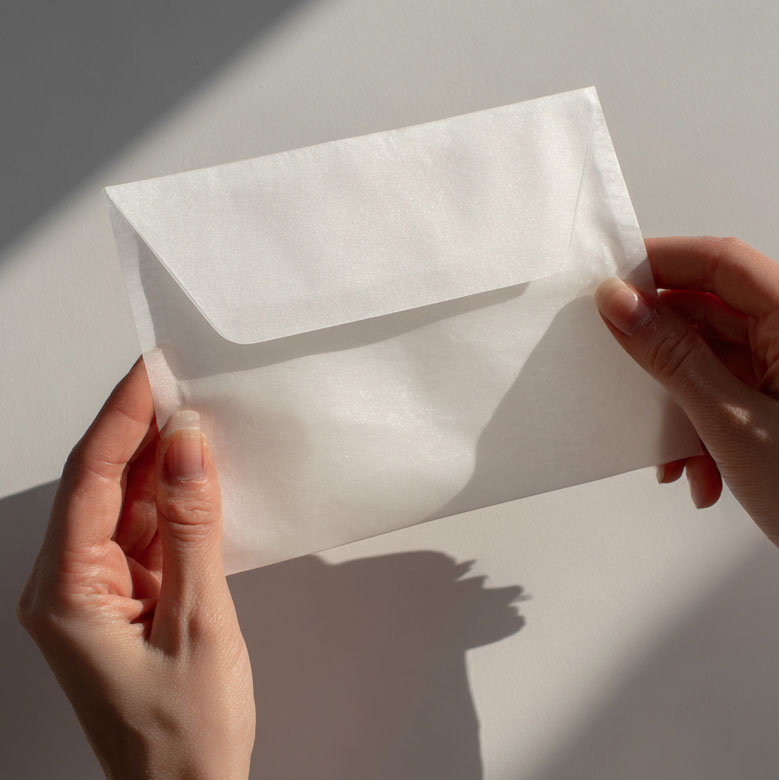 Close-up of hands holding sustainable packaging material in a clean minimal scene